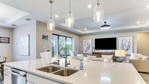 A modern kitchen with a large island, stainless steel appliances, and pendant lighting. - 1 Mi to Boat Launch: Canal-View Cape Coral Gem (Cape Coral)