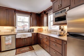 A modern kitchen with wooden cabinets, stainless steel appliances, and a large window providing natural light. - Boulder Dreams! Mtn-View Gem in McLeod (Mc Leod)