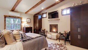 A bedroom with a large bed, a fireplace, a TV, and a wardrobe. - Boulder Dreams Guest House w/ Fire Pit! (Mc Leod)