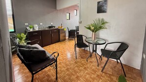 A compact living space with a kitchenette, dining area, and seating. - Apartamento Lapas  (La Fortuna)