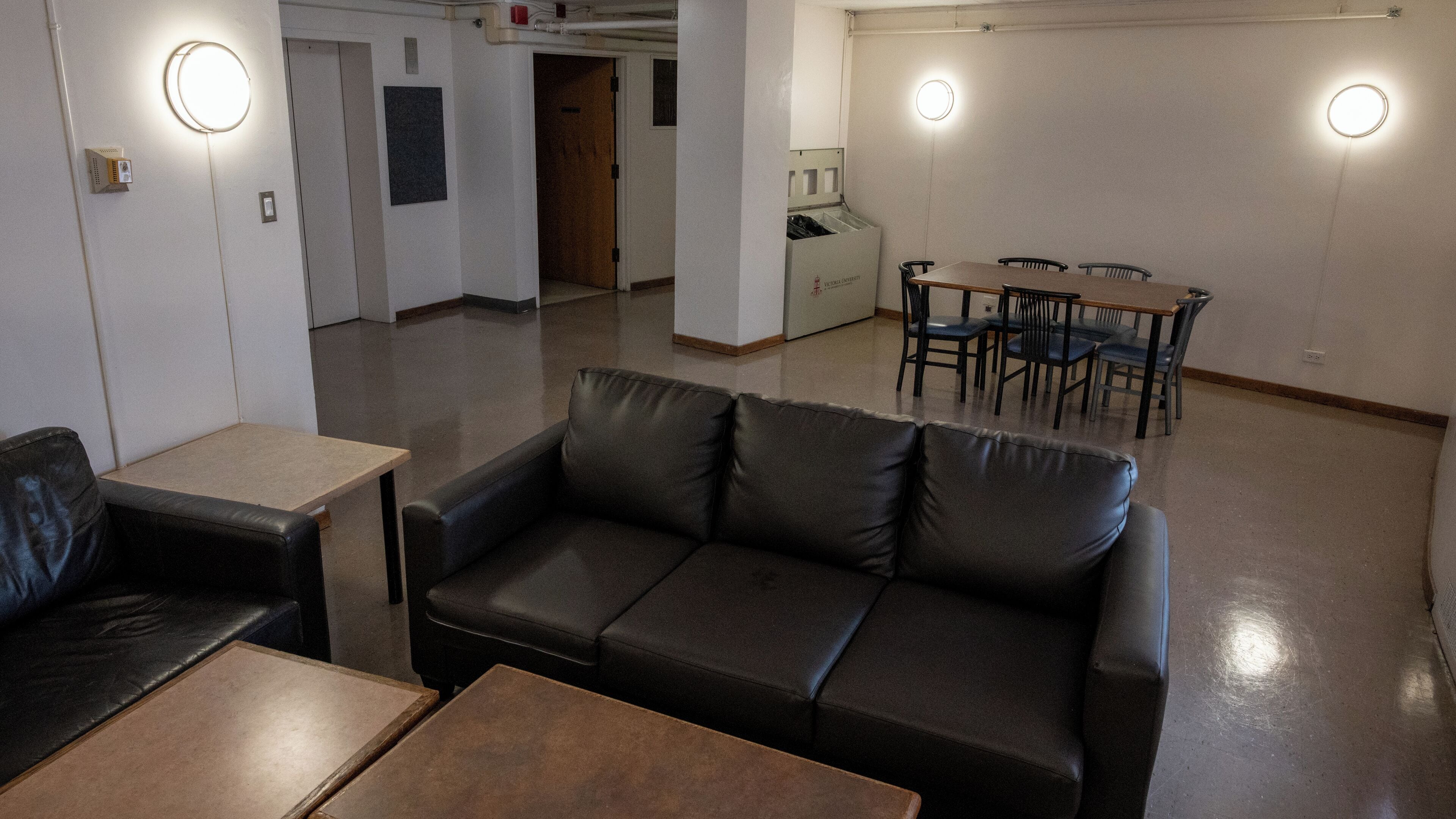 Un interior moderno con un sofá, mesas y una zona de comedor.