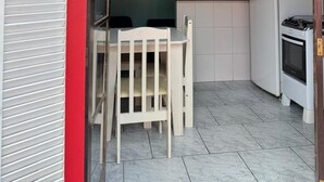 Kompakti keittiö, jossa on ruokailutila, kattotuuletin ja jääkaappi.