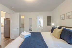 A hotel room with a bed, a bathroom, and a kitchen area. - Play, Stay, Repeat | Cool 1BR (Nashville)