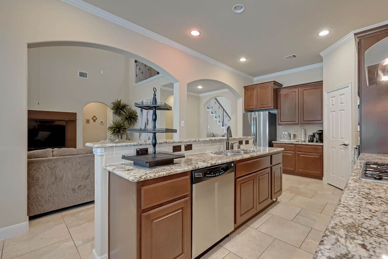 A spacious kitchen with a large island, built-in appliances, and a view to the living area.