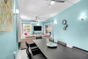 Una sala de estar moderna con una mesa de comedor, sofá y televisor.