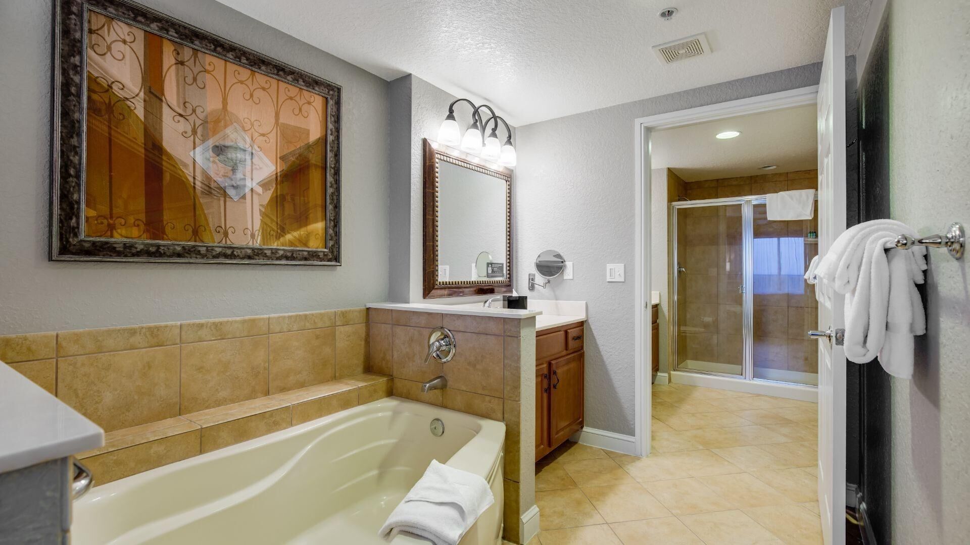 Un baño con bañera, tocador, espejo y cabina de ducha de vidrio.