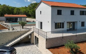 A modern two-story house with a swimming pool, a staircase, and a car parked in front. - Luxurious home in Labin (Labin)