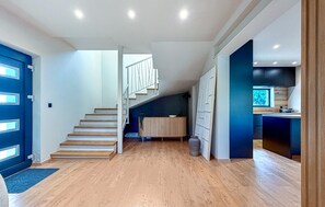 A modern interior with a wooden staircase, a kitchen area, and a dining space. - Luxurious home in Labin (Labin)