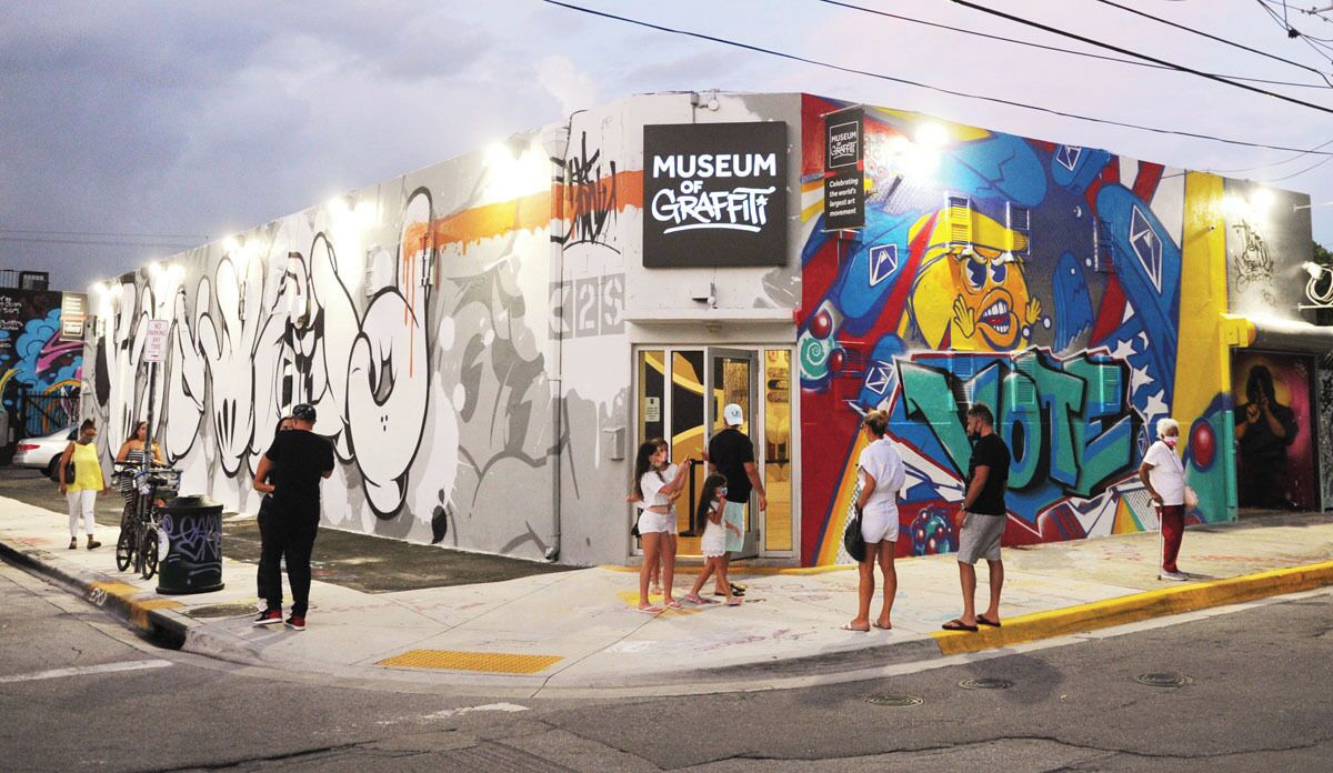 A building with a mural and a sign that reads 'Museum of Graffiti.'