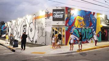 Um edifício com um mural e uma placa que diz 'Museum of Graffiti'.