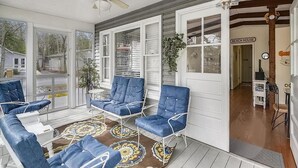 A covered porch with blue chairs, a ceiling fan, and a view of the beach house. - Classic 3BR House | Porch, Pool & Beach Nearby (Bethany Beach)