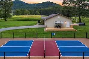 Ein Tennisplatz mit einem Haus im Hintergrund.