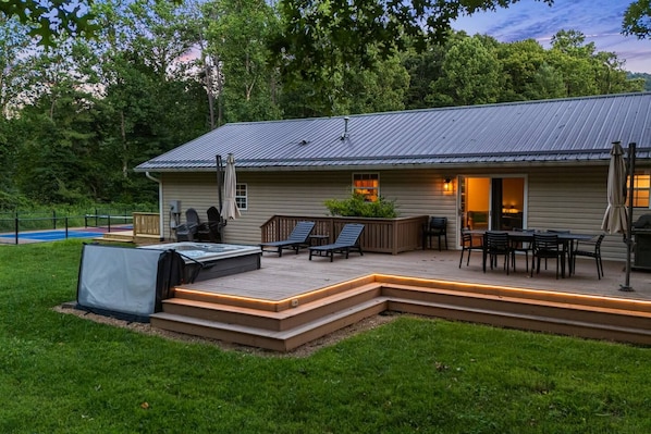 Una casa con terraza, mobiliario exterior y jacuzzi.