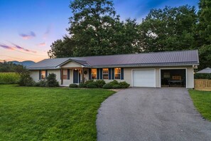 A single-story house with a garage, a front porch, and a driveway leading to the entrance. - Mtn Views, Pickleball Court, Hot Tub & Fire Pit (Arden)