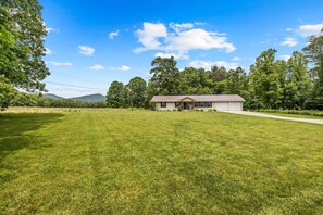 A single-story house with a front porch, a garage, and a well-maintained lawn. - Private Pickleball Court, Hot Tub and Fire Pit (Arden)