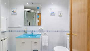 A bathroom with a sink, mirror, toilet, and towel rack.