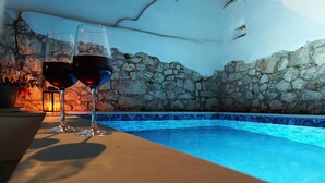 Ein Poolbereich mit Steinwänden und einer gefliesten Kante.