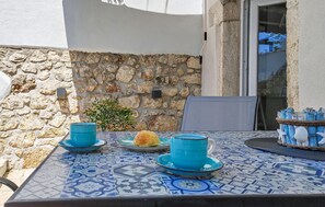 A table with a blue and white patterned tablecloth, a blue bowl, a plate with a pastry, and a blue cup. - Gorgeous home in Grizane with private swimming pool, can be inside or outside (Grizane)