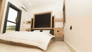 Ein Schlafzimmer mit einem Bett, einem Fernseher und einem Fenster.