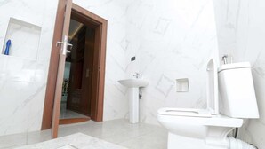 Ein Badezimmer mit Toilette, Waschbecken und Duschbereich.