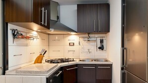 A modern kitchen with dark wooden cabinets, a stainless steel sink, and a gas stove. - Amazing apartment in Moscenicka Draga with WiFi (Moscenicka Draga)