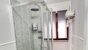 Kylpyhuoneessa on lasiseinällä varustettu suihku, wc ja puulattia.