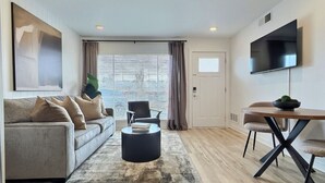 En moderne stue med sofa, sofabord og spisebord.