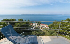 Un balcón con vista despejada al mar y a la costa distante.