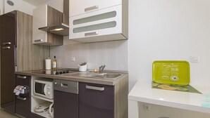 A modern kitchen with a dishwasher, oven, and a sink. There is a green box labeled "Food and Drinks" on the countertop. - 2 bedroom awesome apartment in Brela (Brela)