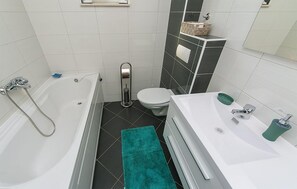 Une salle de bain moderne avec une baignoire, des toilettes et un lavabo.
