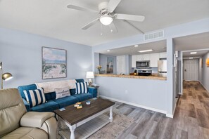 Ein Wohnzimmer mit einer Couch, einem Couchtisch und einem Deckenventilator.
