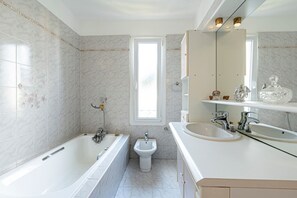 A modern bathroom with a bathtub, a bidet, and a double sink. - Le Ricci - Climatisé, plages à 2 km (Ajaccio)