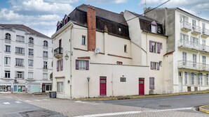 Een gebouw met een rode deur, een schotelantenne en een balkon.