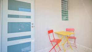 A room with a white door, a small window with blinds, and a tiled floor. - Vibrant Apartment By The Beach (San Juan)