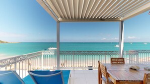 A covered outdoor area with a view of the beach and turquoise sea. - Beautiful beach apartment with sea view (Grand-Case)