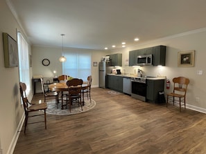 A modern kitchen with a dining area, wooden flooring, and built-in appliances. - 2 Bedroom Duplex Vance Villa in UPTOWN Lexington! (Lexington)
