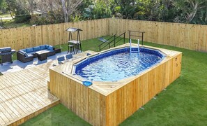 A wooden deck with a hot tub, outdoor seating, and a grassy area. - Sunny Nokomis Getaway•Private Pool•Backyard Oasis (Nokomis)
