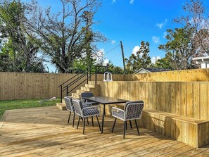 A wooden deck with a table and chairs, surrounded by a wooden fence. - Sunny Nokomis Getaway•Private Pool•Backyard Oasis (Nokomis)