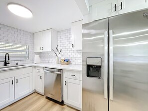 A modern kitchen with white cabinetry, a stainless steel refrigerator, and a built-in water dispenser. - Sunny Nokomis Getaway•Private Pool•Backyard Oasis (Nokomis)