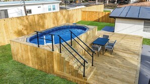 A wooden deck with a hot tub, a set of stairs, and outdoor furniture. - Sunny Nokomis Getaway•Private Pool•Backyard Oasis (Nokomis)