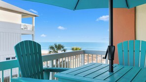 A balcony with turquoise chairs and a table, overlooking a beach and ocean. - Condo With Gulf View Direct Beach Access, Indoor/outdoor Pool (Orange Beach)