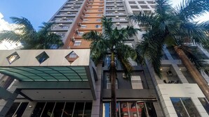 Un edificio de gran altura con varios pisos, unidades de aire acondicionado y balcones.