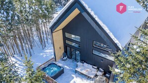 En moderne skiferiebygning med jacuzzi og udendørs siddeområde.