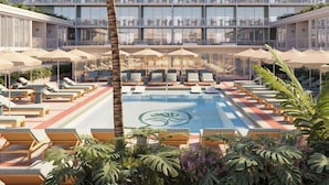 A hotel pool area with sun loungers, umbrellas, and a large building in the background. - Sítio El Tropicano (San Antonio)