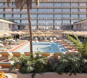 A hotel pool area with sun loungers, umbrellas, and a large building in the background. - Sítio El Tropicano (San Antonio)