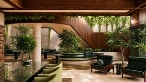 A modern interior with a curved seating area, a staircase, and greenery. - Sítio El Tropicano (San Antonio)