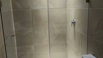 Habitación cuádruple superior | Baño | Regadera, toallas, jabón, shampoo