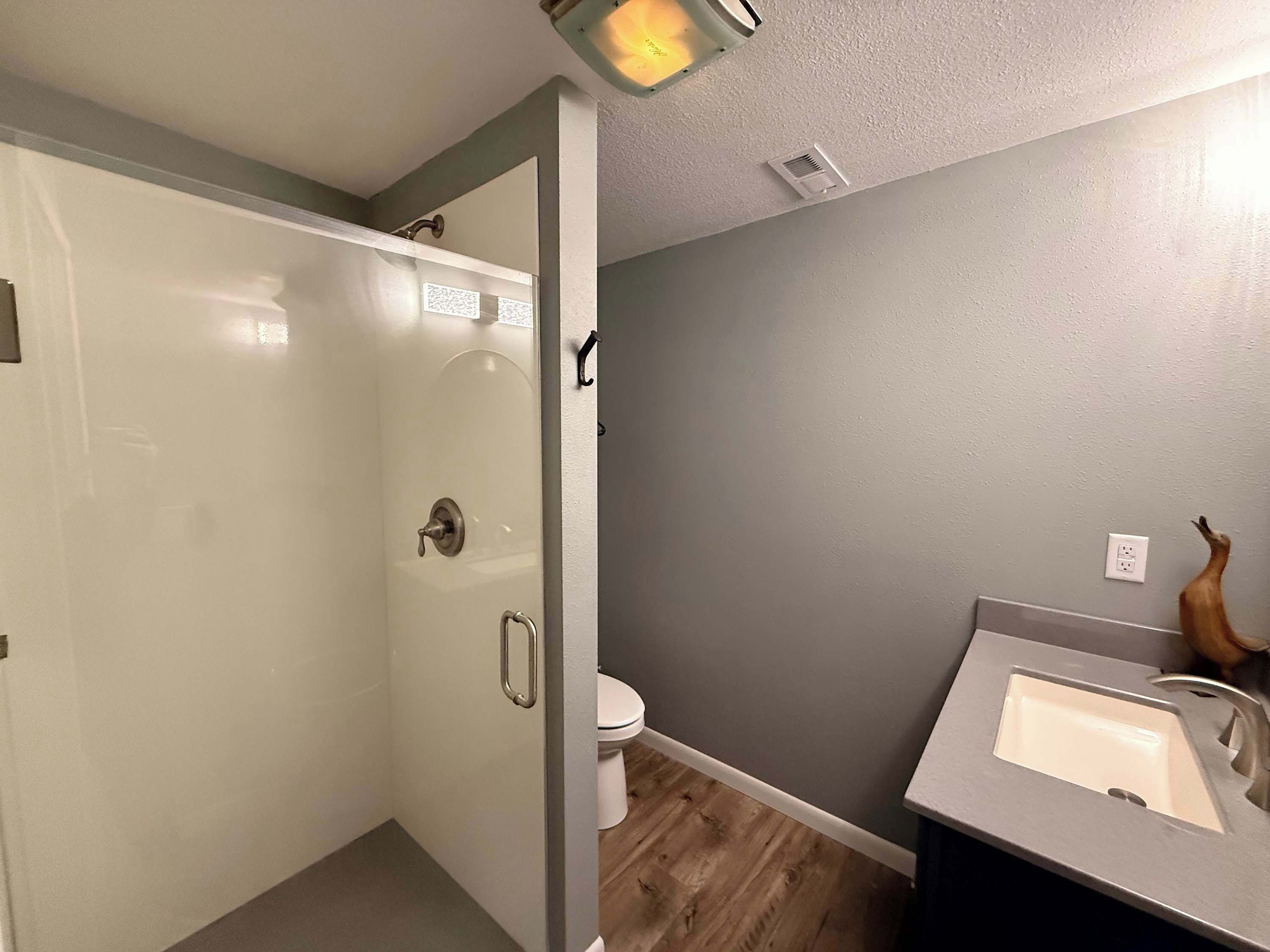 A bathroom with a shower, toilet, and sink.