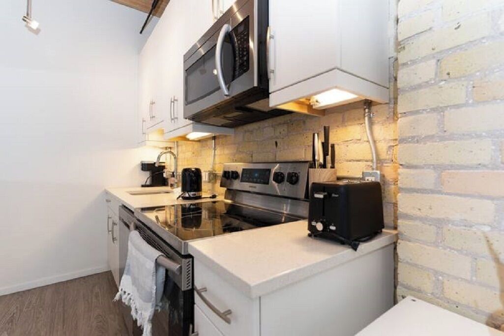 A compact kitchen with a microwave, oven, and toaster.