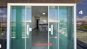 Entrada de un edificio moderno con puerta de vidrio, una cocina visible en el interior y el número 4 en la pared.